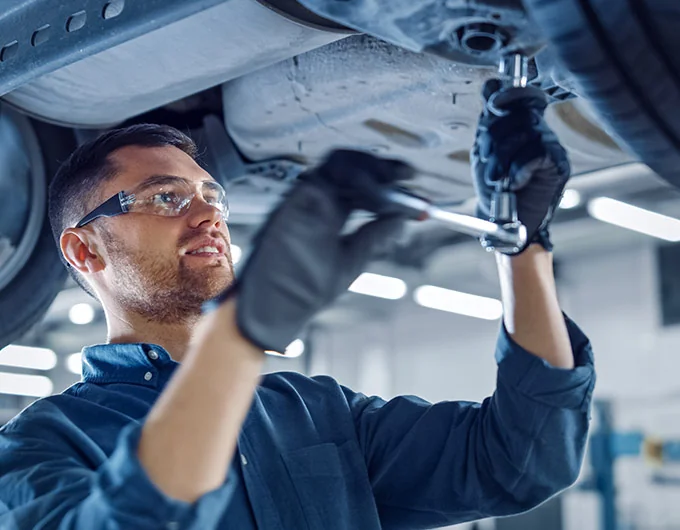 BMW mechanic under the vehicle servicing