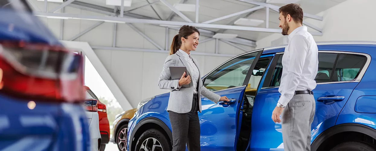 Car saleswoman showing a customer a vehicle