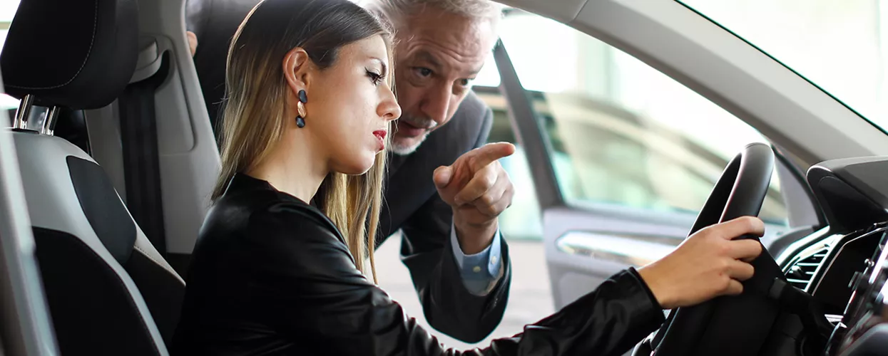 Car salesman showing a customer the interior of a vehicle