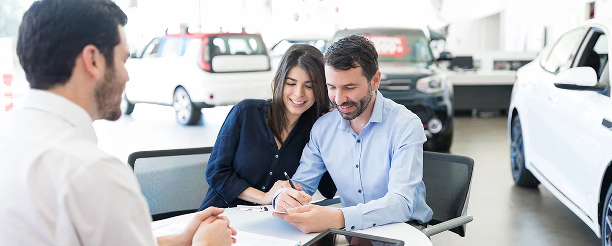 Happy couple signing the papers for there new car at Wesley Chapel Nissan
