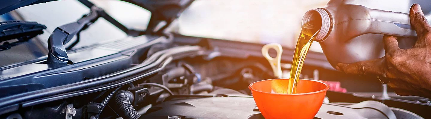 mechanic pouring oil into the engine