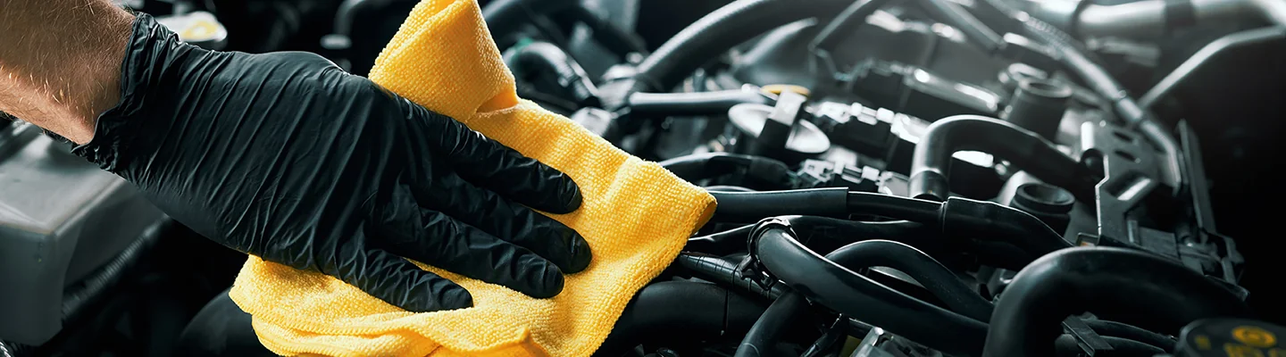 car mechanic wiping down area of service