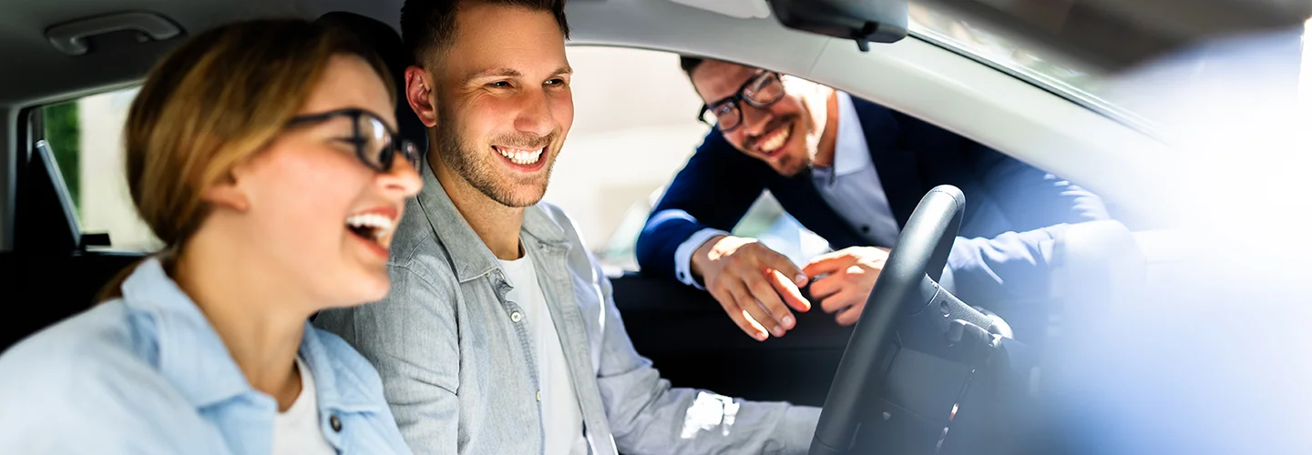 Sales person showing customers the insdie and features of a new BMW