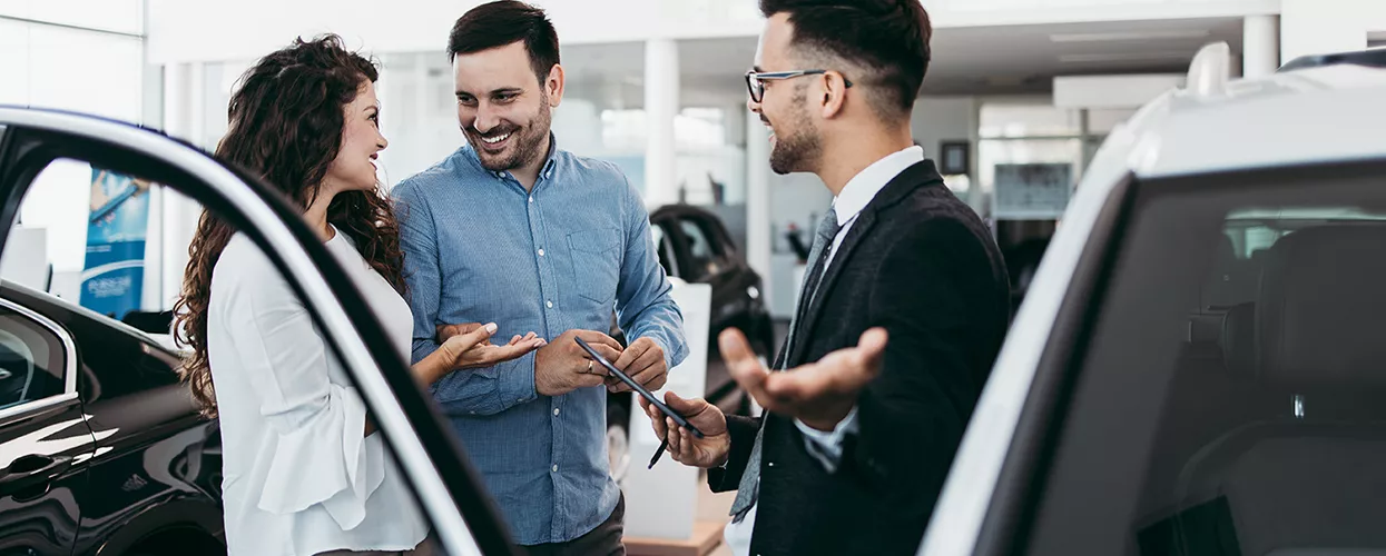 Sales person showing customers a new Nissan