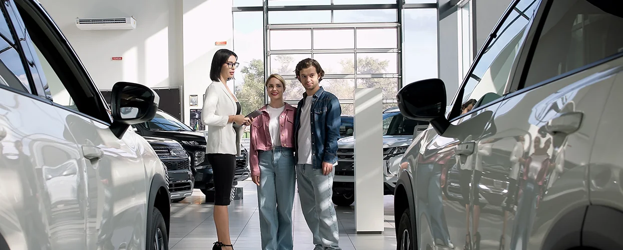 Sales person showing customers new Nissian SUVs