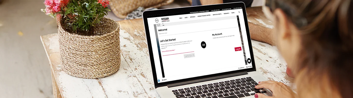person on laptop browsing the Nissan of Orange Park website shopping online