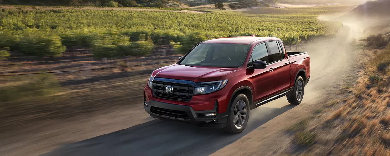 Red Honda Ridgeline offroad on dirt road