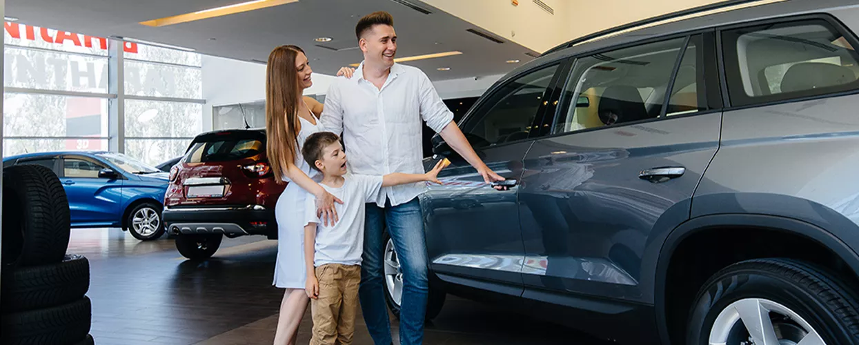 Family looking at a new vehicle at a car dealership