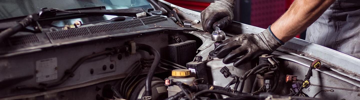 Automotive service technician performing maintenance on a vehicle