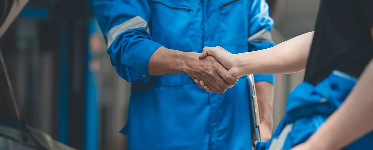 Two service mechanics shaking hands