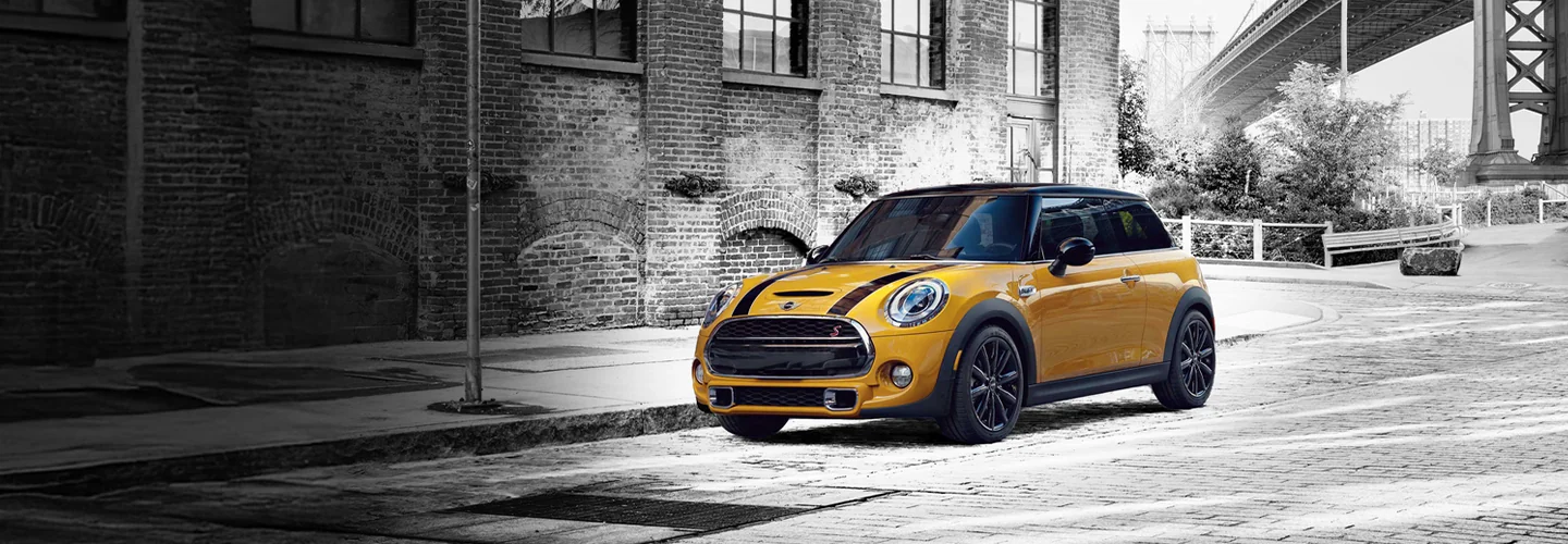 Yellow MINI Copper parked on a street with a black and white background