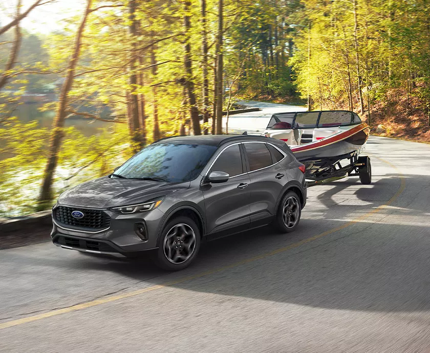 Ford Escape towing a boat back to the boat dealer