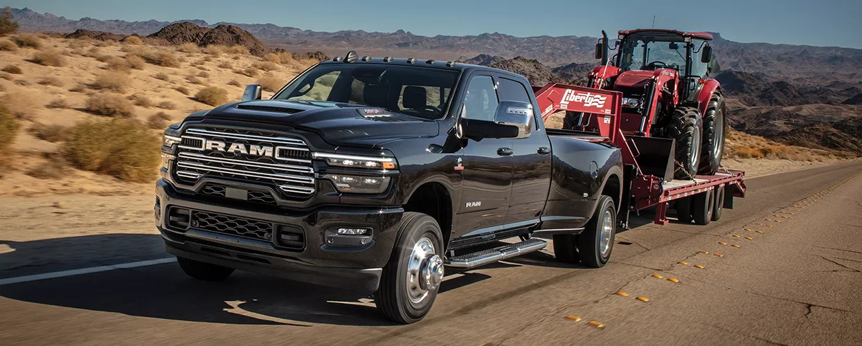 RAM truck towing a backhow on a trailer
