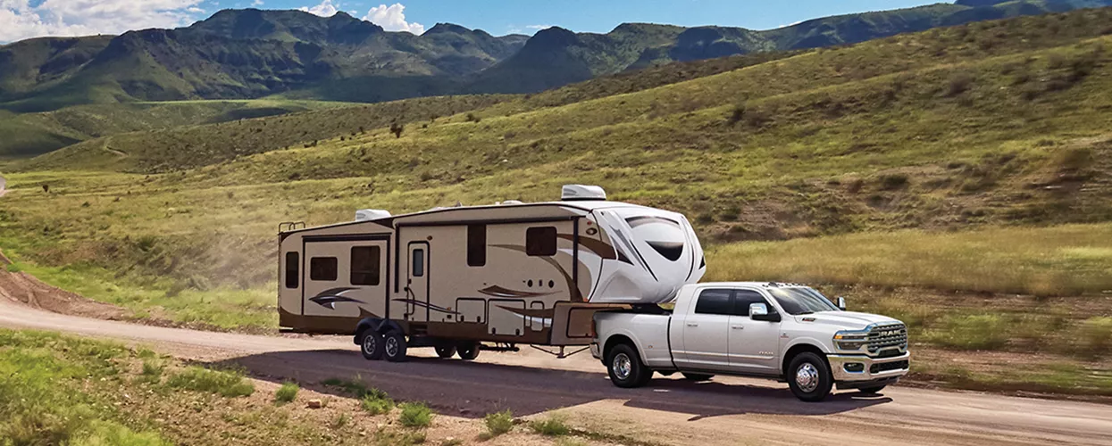Ram truck towing a camper through the mountains