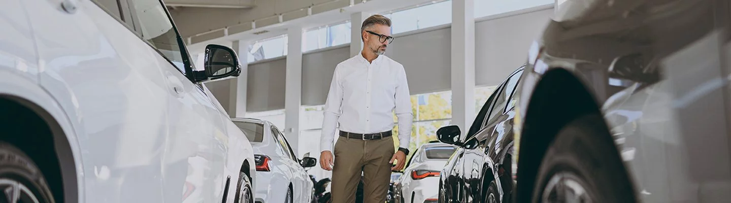 guy standing between two vehicles looking at them