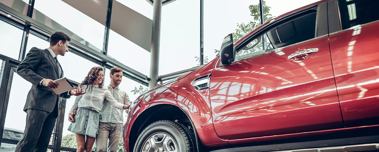 Couple looking at used vehicles in a car delership