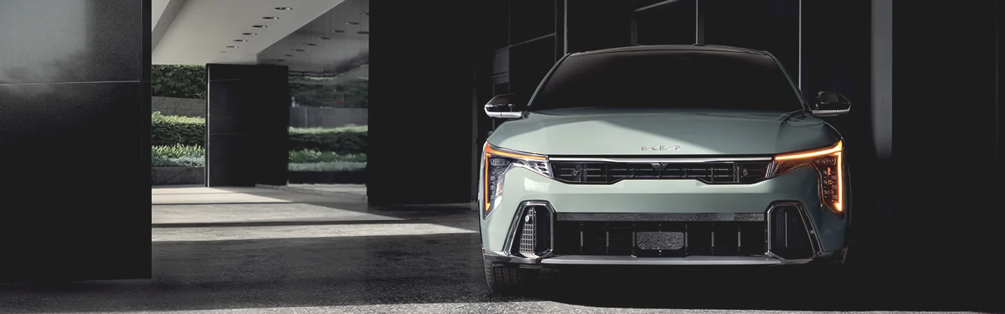 Front view of a parked 2025 Kia K4 next to a build