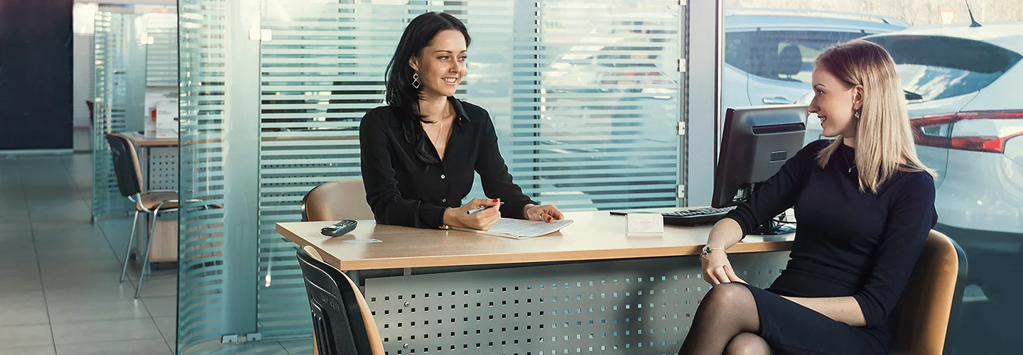 Sales person talking to customer about their new car