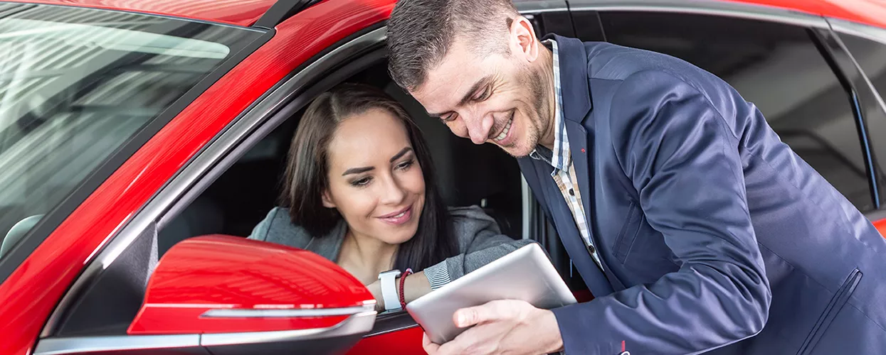 Car salesman talking with a customer in a car