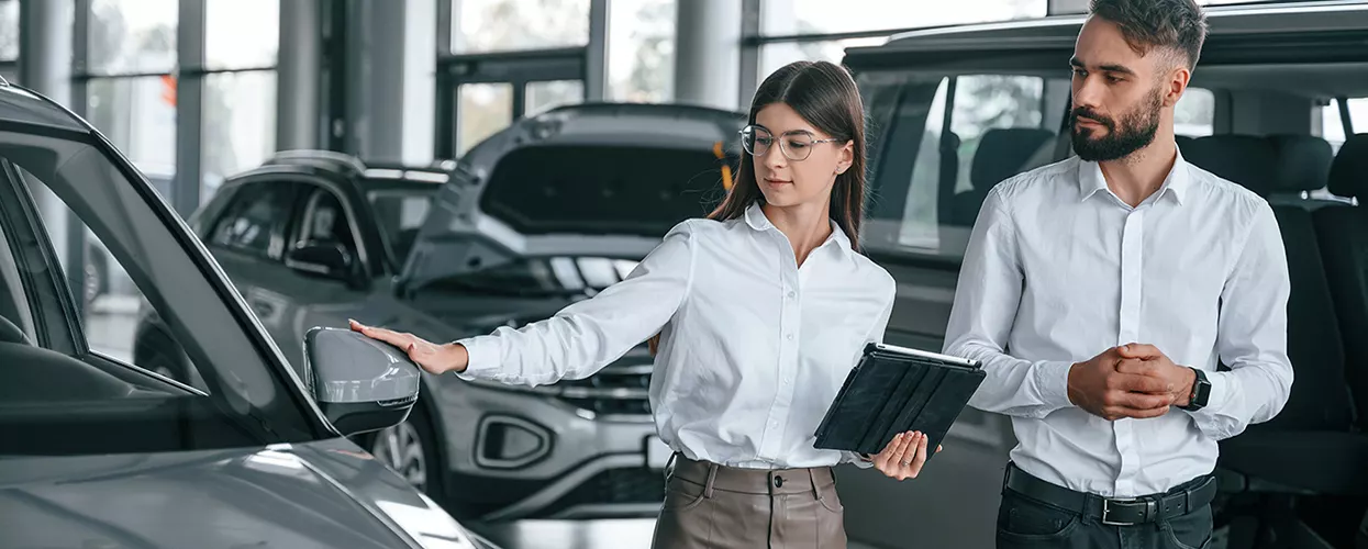 Car salesman showing a customer a vehicle at a Land Rover dealership