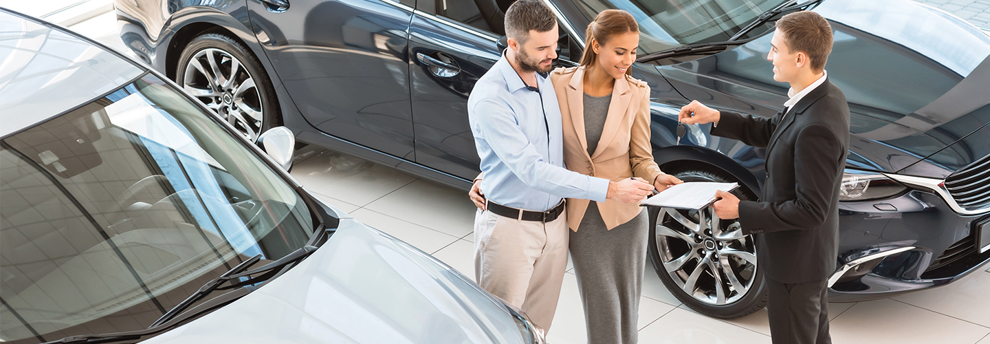 couple buying a new car in showroom
