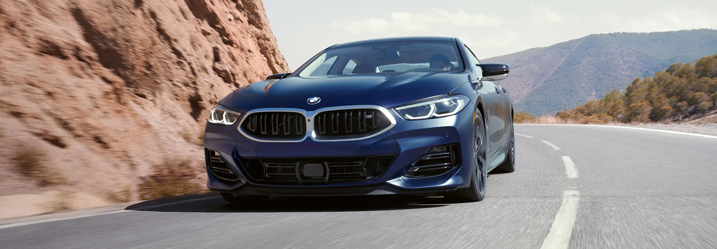 Black BMW drving on a mountain side road