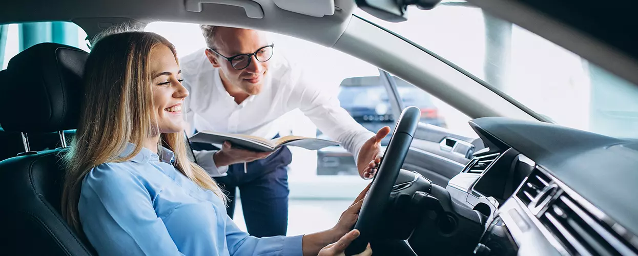 Car salesman showing a customer the interior of a vehicle