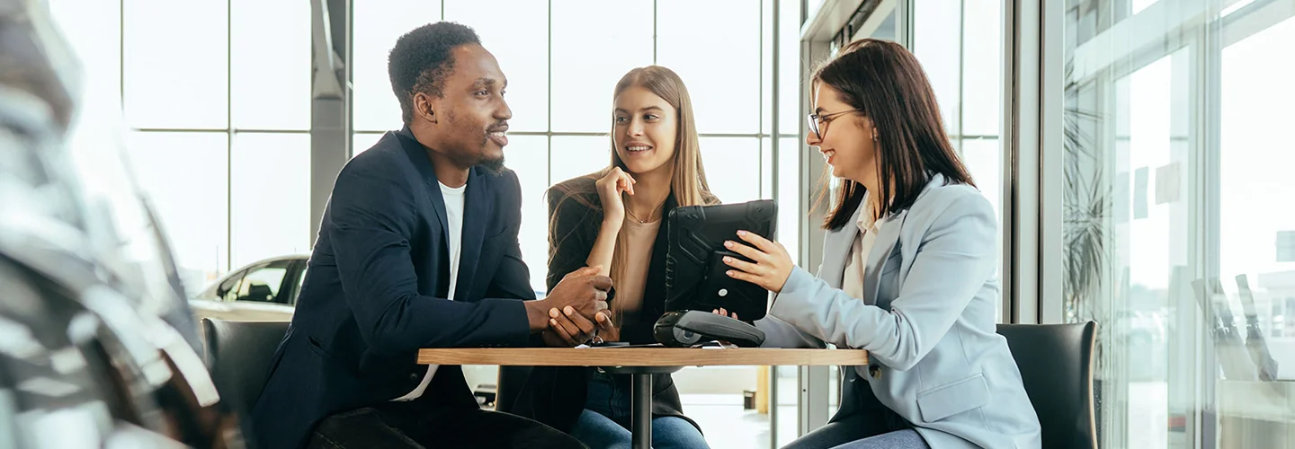 Sales person going over new car infrotmation with customers