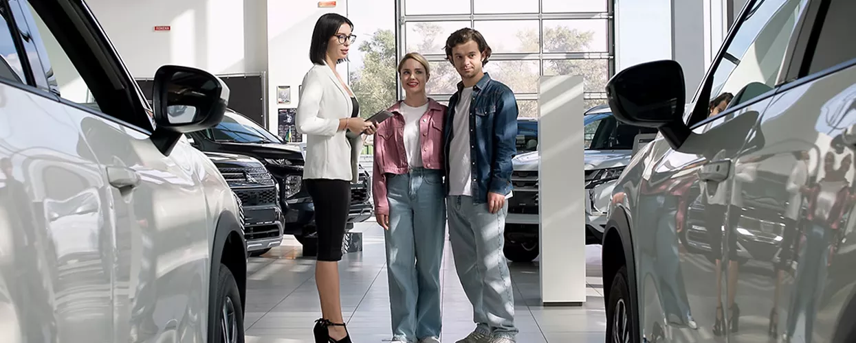 Car shoppers meeting with a dealership representative inside a modern SUV showroom while exploring new vehicle options