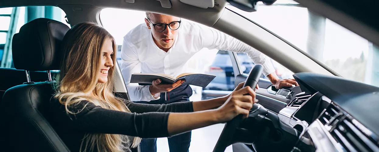 Car salesman showing a customer the interior of a vehicle