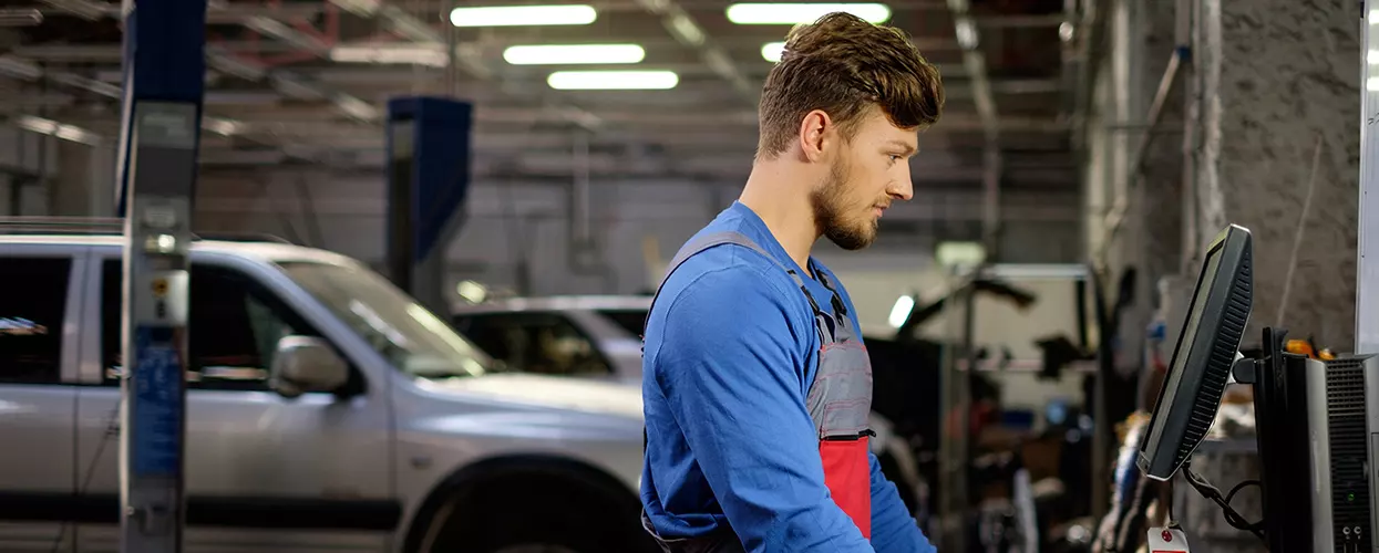 Service mechanic looking at a screen in a service bay
