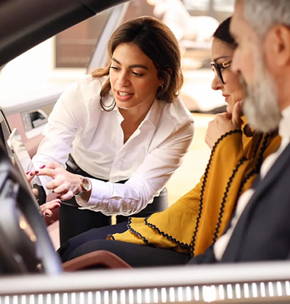 rep explaining features of new car to couple
