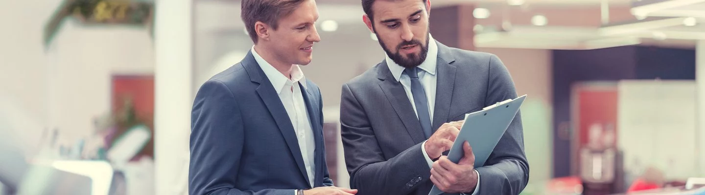 two guys looking over papers on a clip board