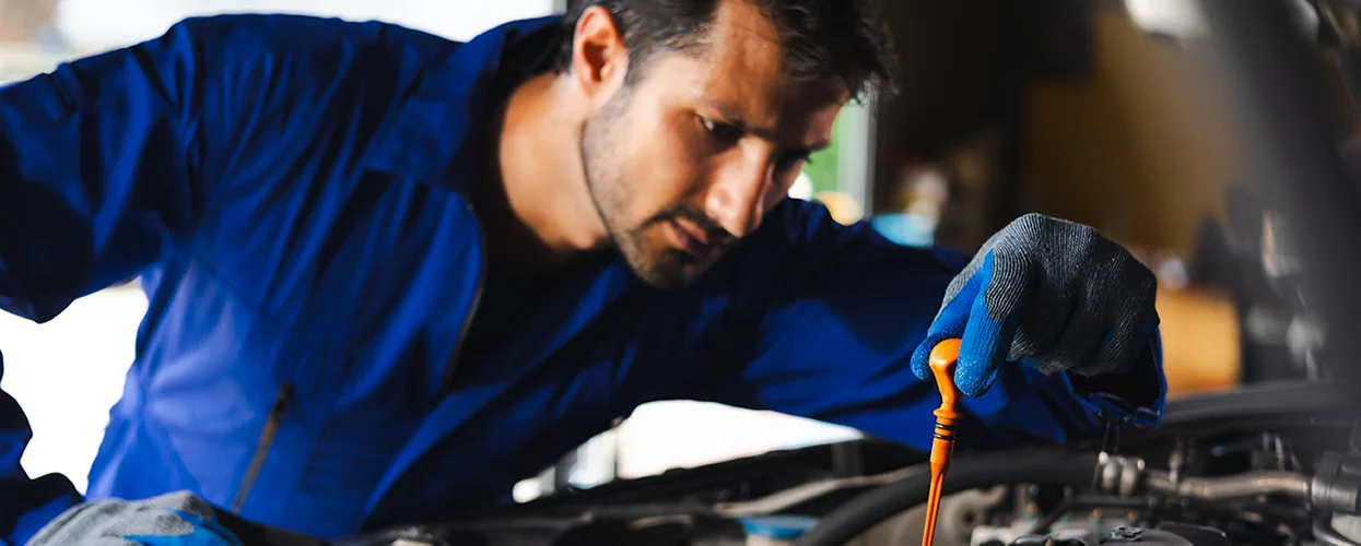 Service tech checking oil
