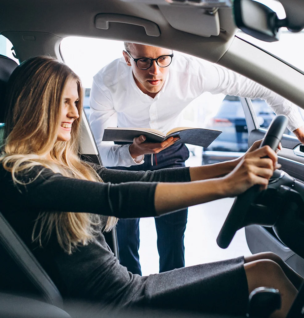 Sales person showing a vewy happy women a car