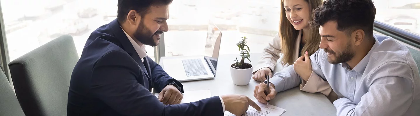 husband and wife looking over contract with salesman