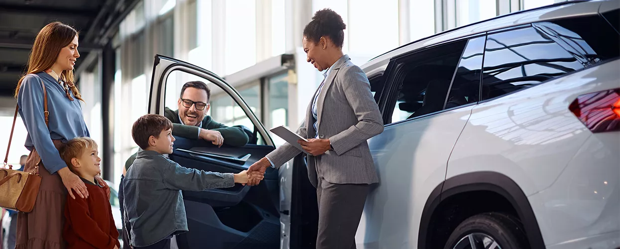 Car saleswoman showing a family a new car