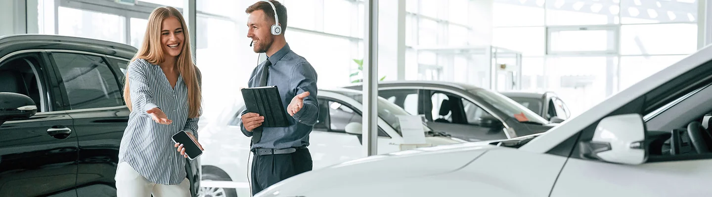 Sales person showing customer a Pre-Owned Lexus GX