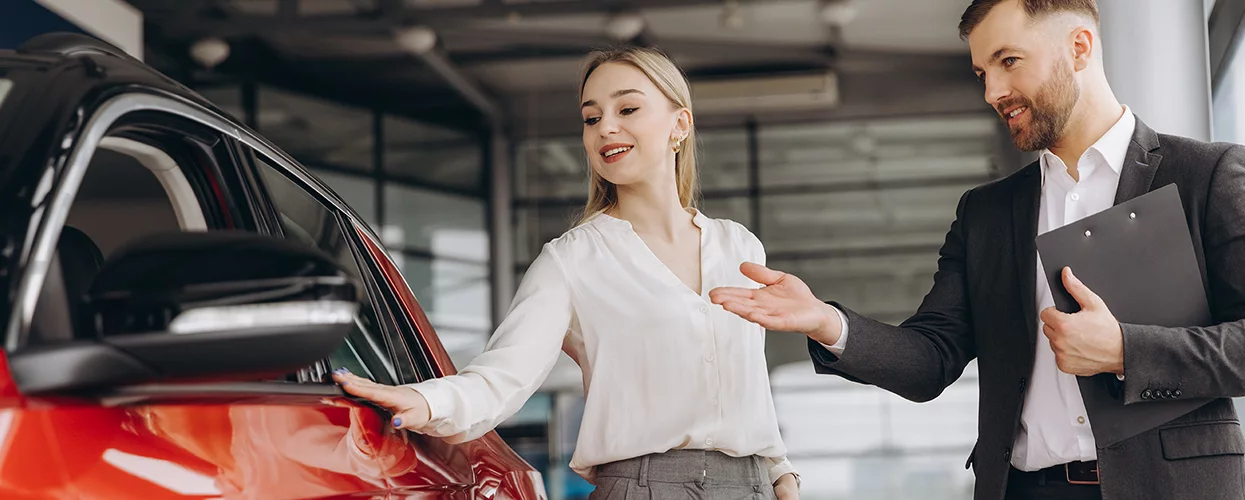 A car shopper with car salesperson in the dealership showroom