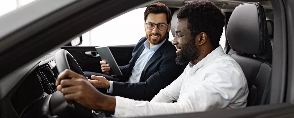 Car salesman showing a customer the interior of a vehicle