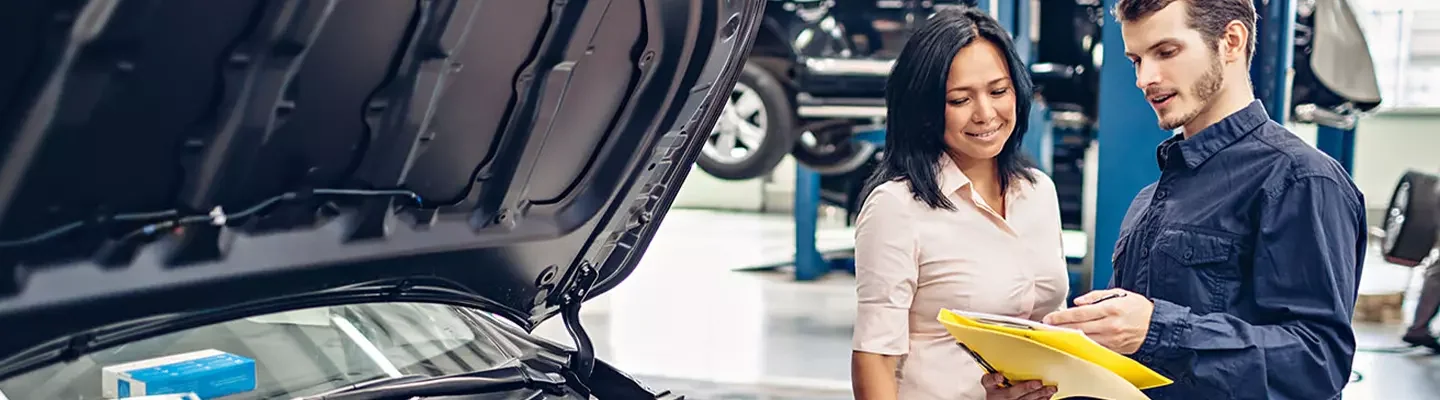 auto mechanic discussing repair details with another person