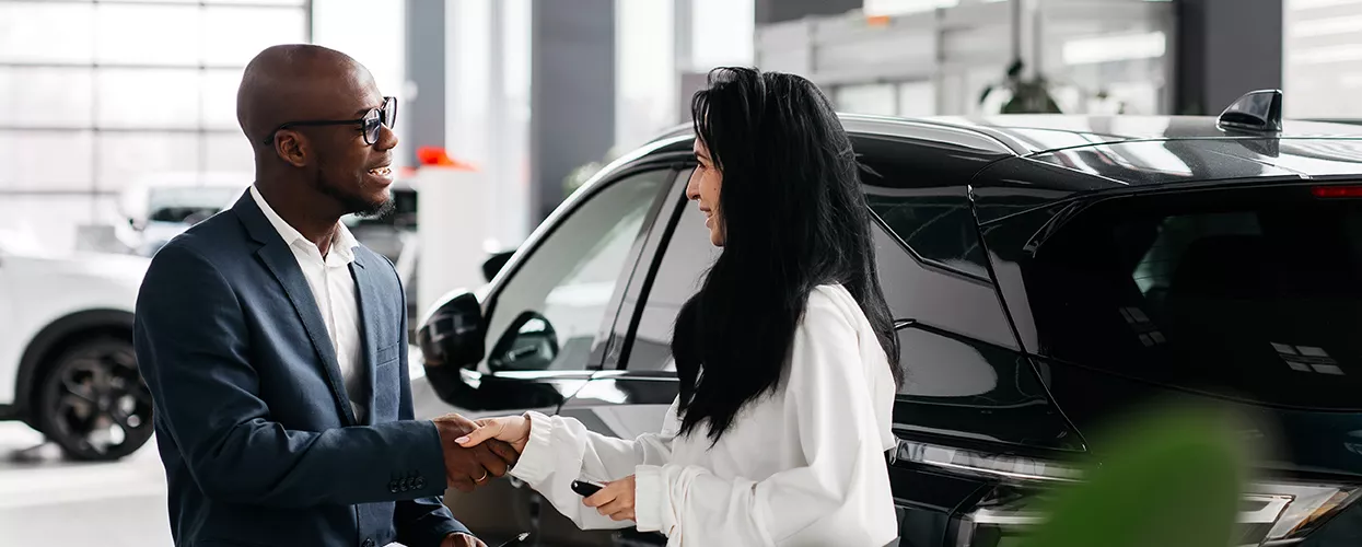 Car salesman shaking hands with a customer