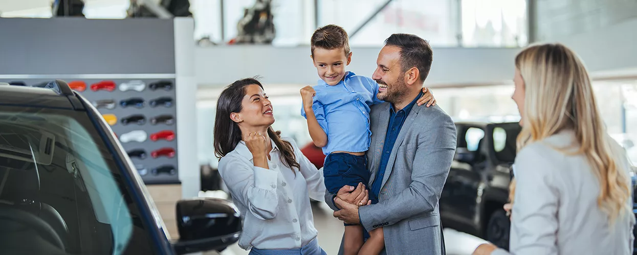 Family looking at a new vehicle in a car dealership