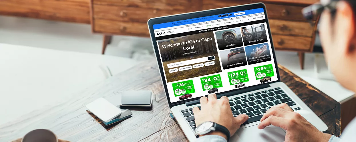 Man using his laptop to browse the Kia of Cape Coral website
