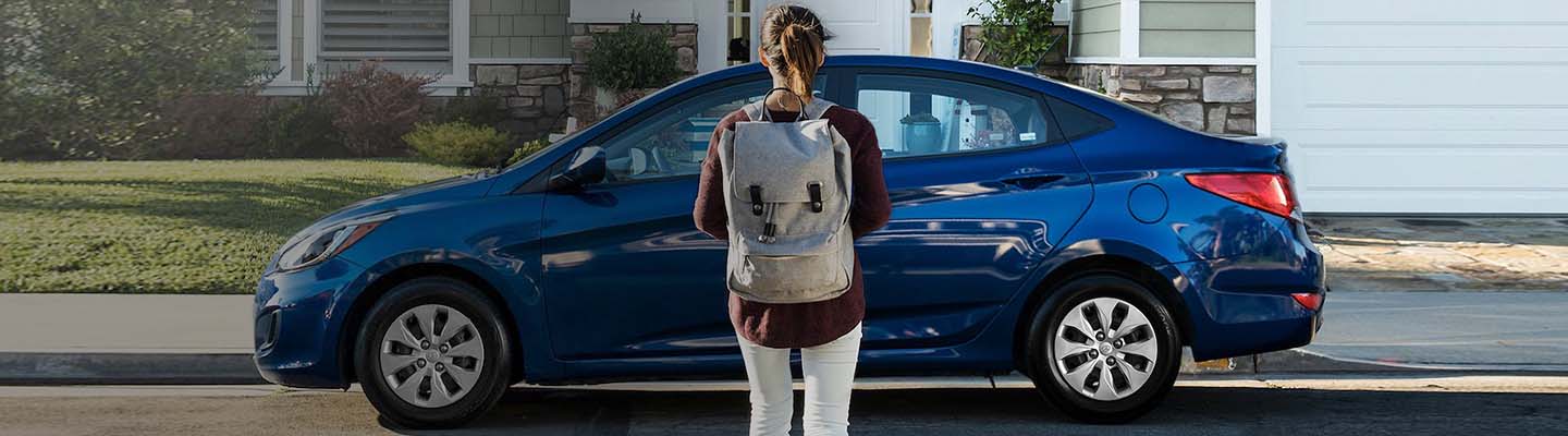 Young woman facing parked vehicle