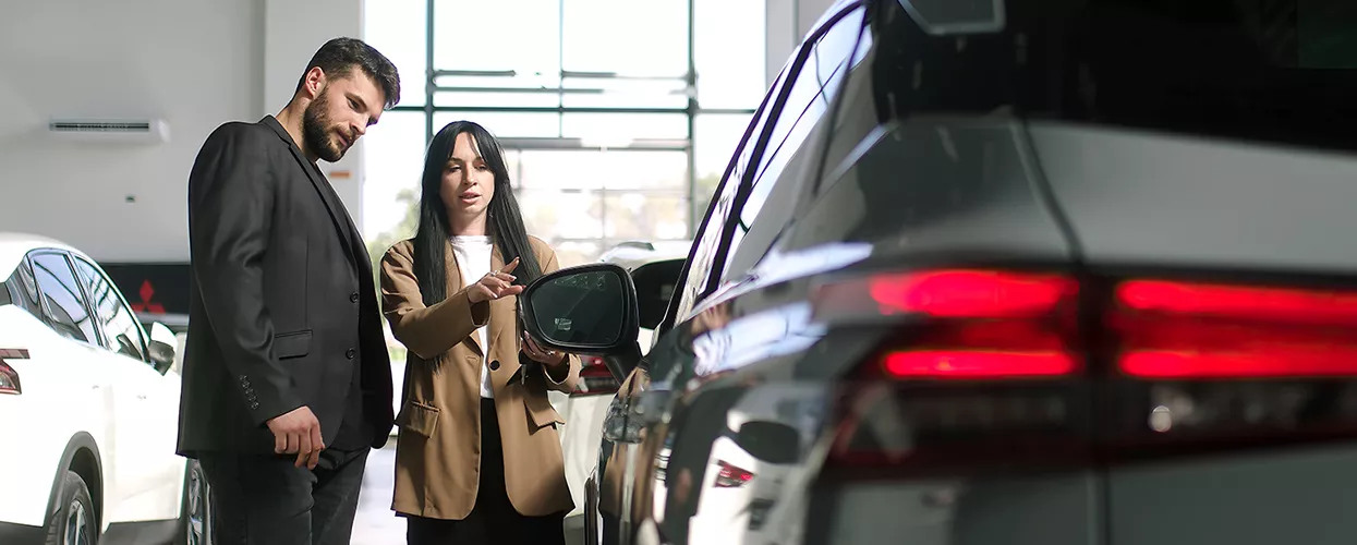Car saleswoman showing a customer a vehicle