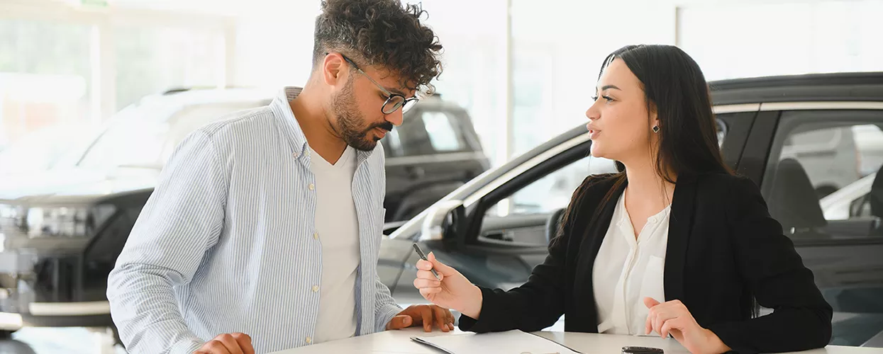 Customer reviewing new Chevrolet warranty coverage details with a dealership advisor