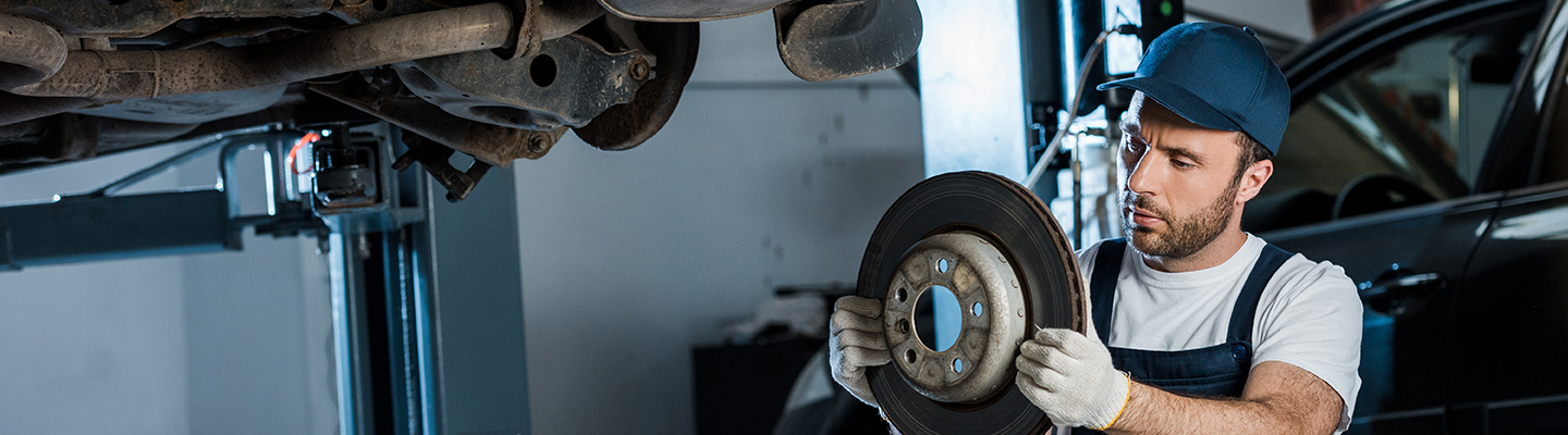 auto mechanic working on car brakes