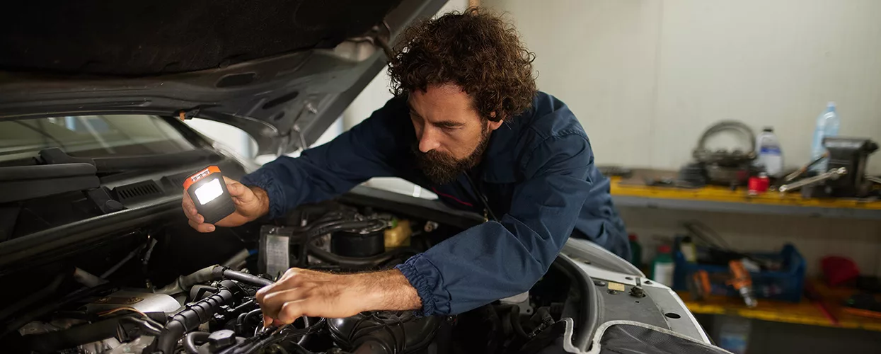How Often Should You Service Your Honda in Florida? in Auto repair technician diagnosing a vehicle engine during automotive maintenance service in a professional repair shop