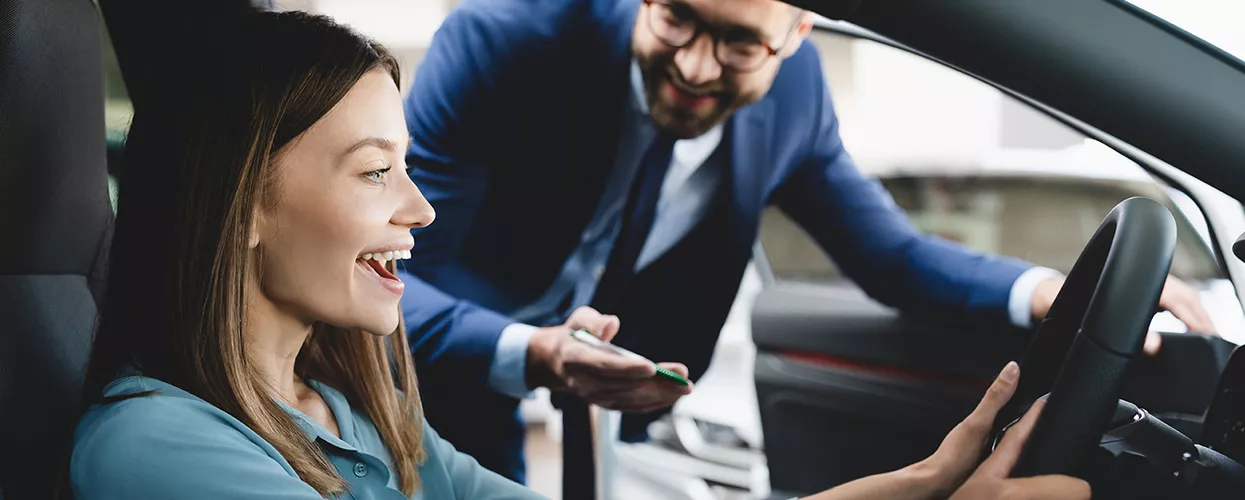 Car salesman showing a customer the interior of a vehicle